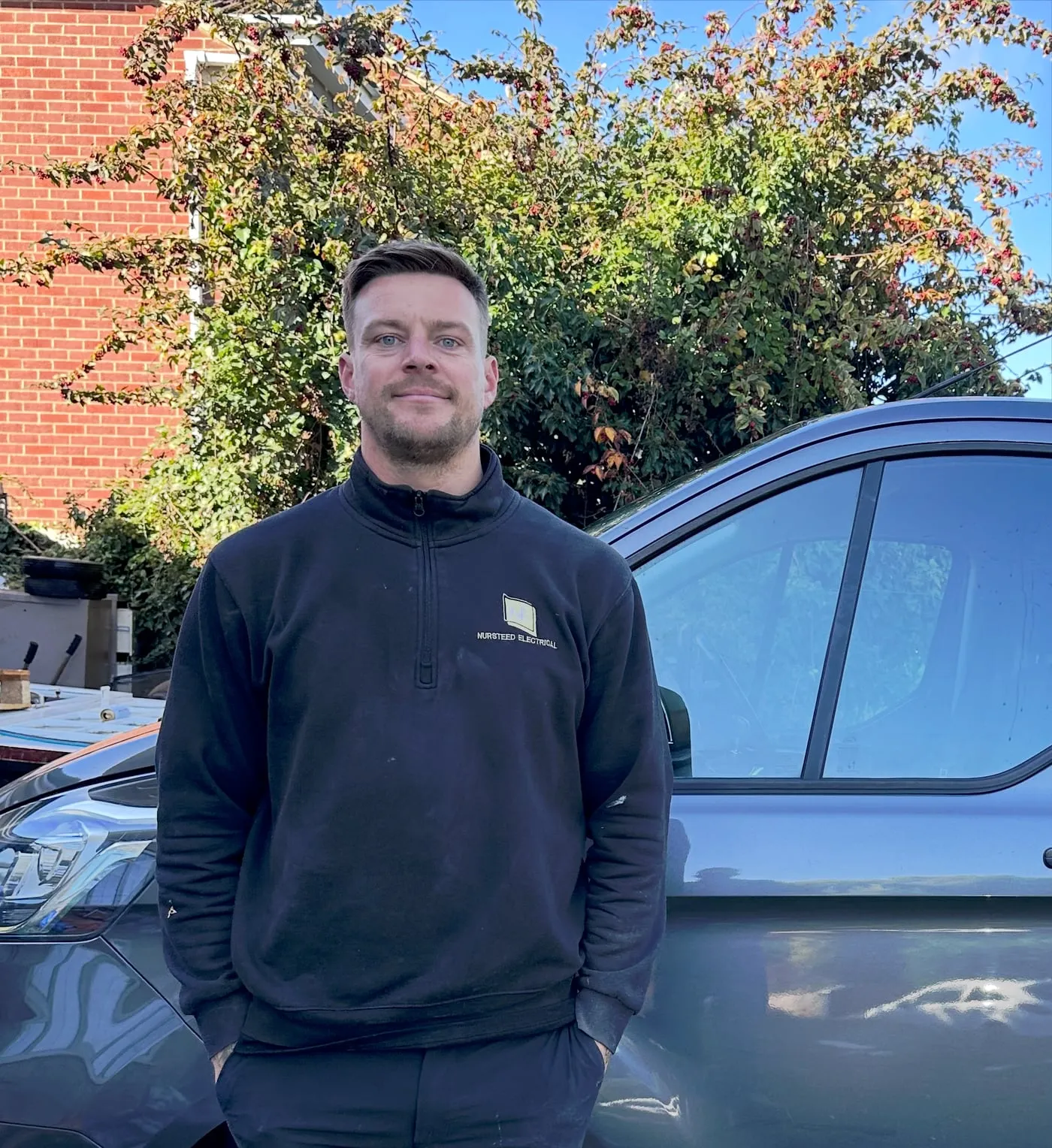 Jack from Nursteed Electrical, smiling in a company sweatshirt